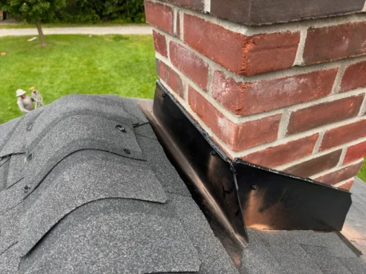 new shingle replacement company for historic building red brick chimney with black shingles